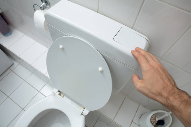 Close-up Of Man Finger Pressing On Button For Flushing Toilet - Zdjęcie, obraz