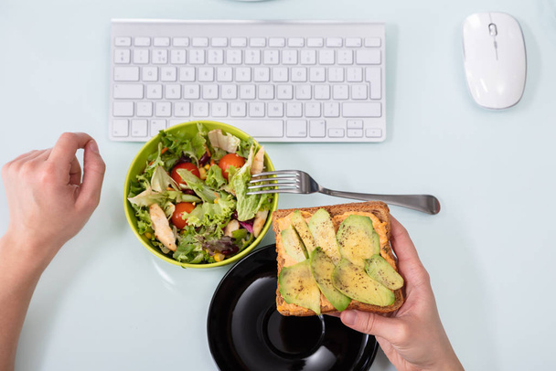 An Elevated View Of Person Holding Healthy Breakfast In Office - Foto, immagini