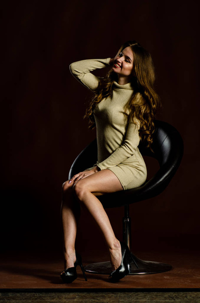 sensual attractive woman in shiny dress posing on black background  - Фото, изображение