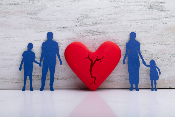 Broken Heart Between Cutout Blue Family Against White Textured Background - Foto, immagini