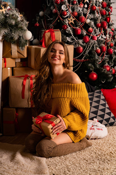 beautiful brunette young  woman posing near fireplace in Christmas decorated studio  - Foto, Imagem