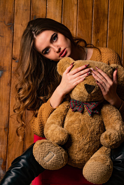 krásná brunetka žena s medvídkem pózování v dřevěném studiu   - Fotografie, Obrázek
