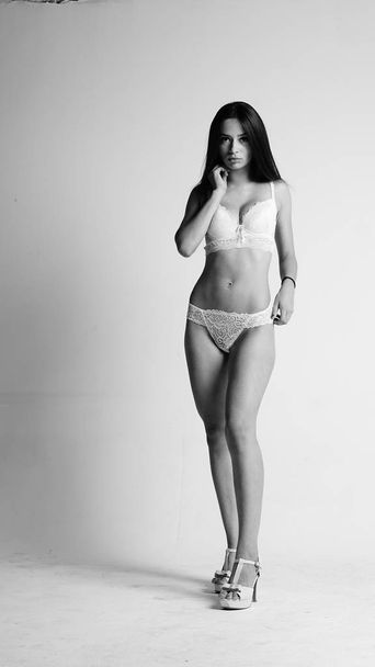 Girl in white lingerie and high heels posing on white background.  - Fotoğraf, Görsel