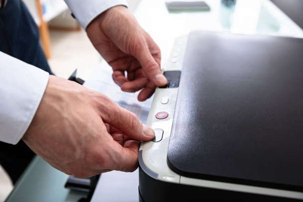 Close-up Of Businessman Pressing Printer's Button In Office - Foto, Imagen