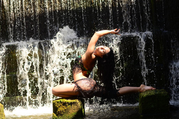 Fiatal barna modell jelentő ellen egy vízesés - Fotó, kép
