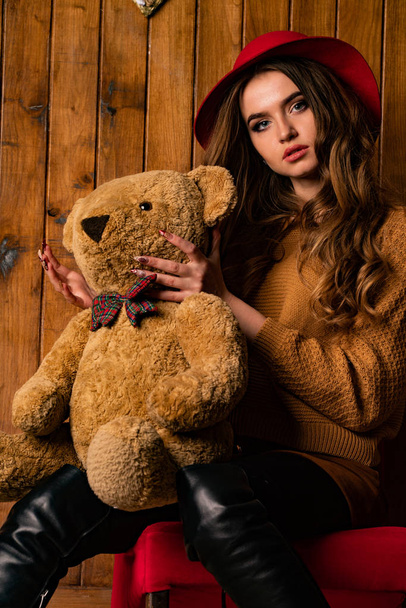 krásná brunetka žena s medvídkem pózování v dřevěném studiu   - Fotografie, Obrázek