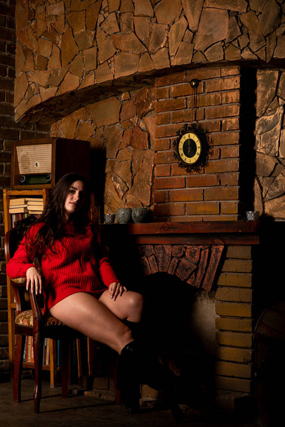 Krásná sexy nahá žena v červeném svetru na tmavém pozadí    - Fotografie, Obrázek