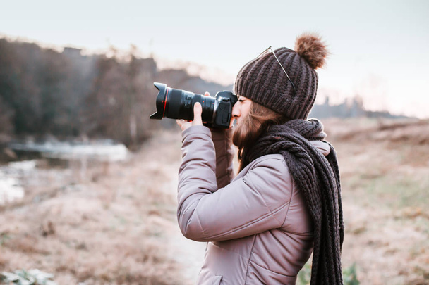 Female photographer talking pictures outdoor with camera. Nature photography - Valokuva, kuva