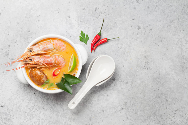 Tom Yum soupe thaïlandaise traditionnelle aux fruits de mer, champignons, lait de coco et épices chaudes. Vue supérieure avec espace de copie - Photo, image