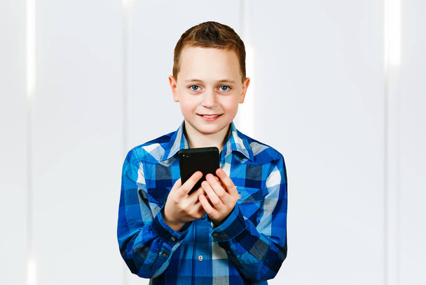 smiling boy reading text on smartphone. leisure, children, technology, communication and people concept - Фото, изображение