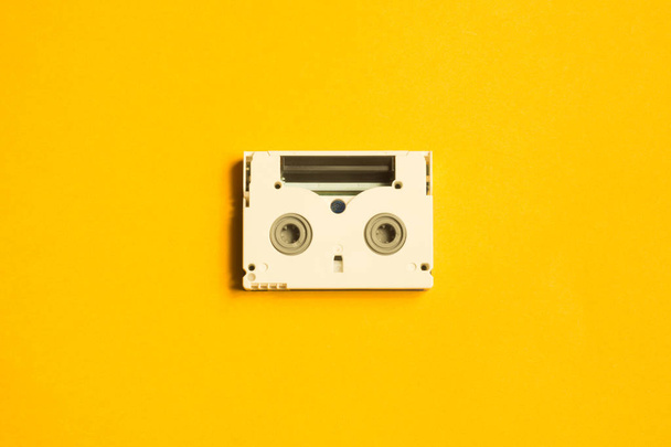 Digital video cassette on yellow background. mini cassette. copy space - Foto, Bild