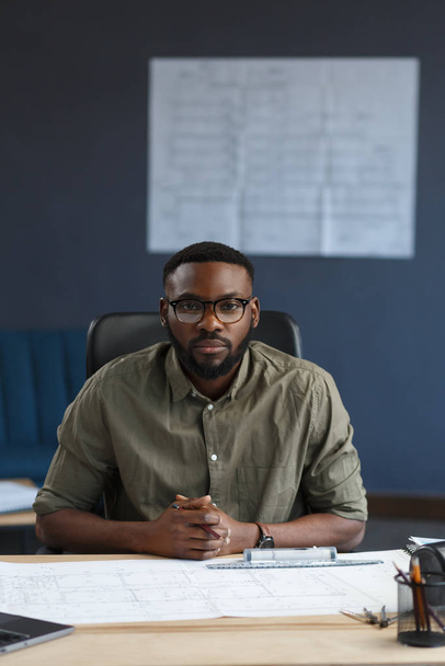 Afro-American architect working in office with laptop.Business portrait of black handsome bearded man wearing eyeglasses sitting at workplace.Confident businessman became successful.Business concept - Фото, зображення