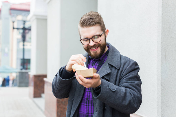 Az ember kezében egy tányér hagyományos ízletes zsidó étel falafel készült csicseriborsó az utcán élelmiszer fesztivál - Fotó, kép