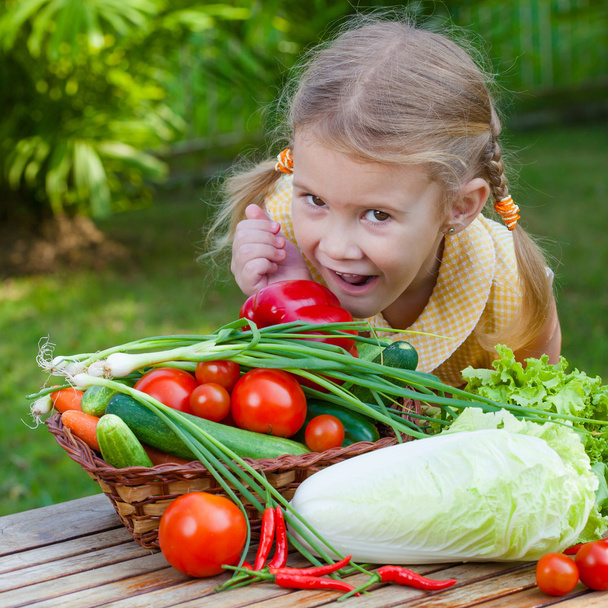 girl holding a basket of vegetables (cucumber, pepper, tomato, o - Valokuva, kuva
