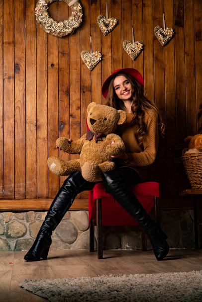 bella bruna donna con orso giocattolo posa in studio di legno   - Foto, immagini