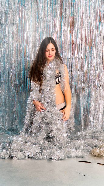beautiful sexy woman in shiny christmas tinsel posing in studio, holiday concept    - Photo, Image