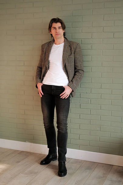 Tall handsome man standing next to grey wall - Foto, immagini