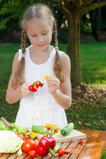 girl holding a sticks vegetables (cucumber, pepper, tomato) - Valokuva, kuva