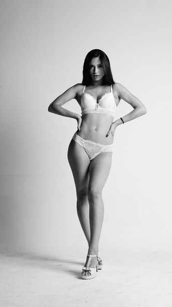 Girl in white lingerie and high heels posing on white background.  - Valokuva, kuva