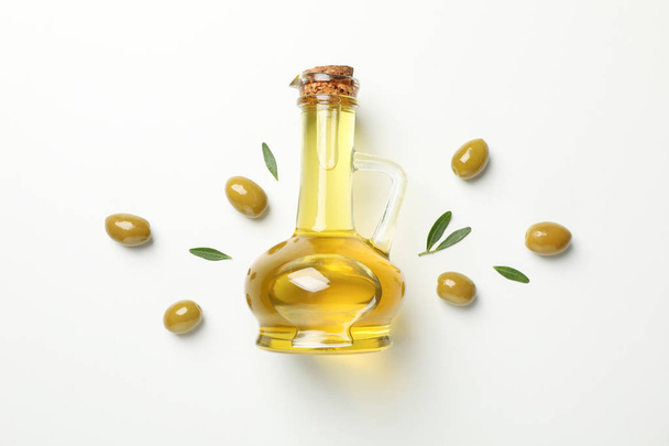 flache Lage mit einem Krug Olivenöl, Oliven und Blättern auf weißem Rücken - Foto, Bild
