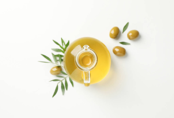 Jug with olive oil, olives and leaves on white background, top v - Foto, imagen