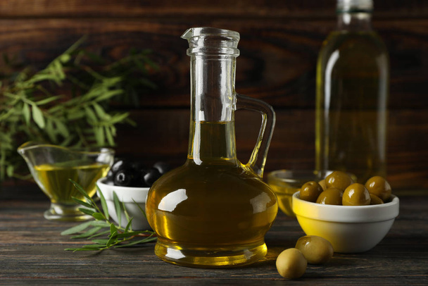 Composition with olive oil and olives on wooden background, clos - Photo, Image