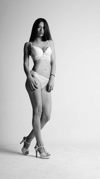 Girl in white lingerie and high heels posing on white background.  - Foto, Bild