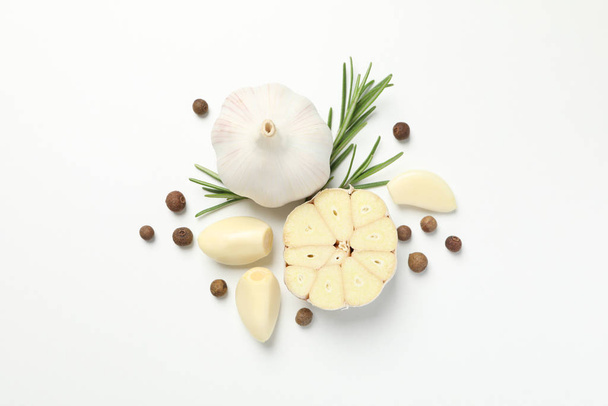 Bulbes d'ail, tranches, épices, persil, romarin sur fond blanc
 - Photo, image