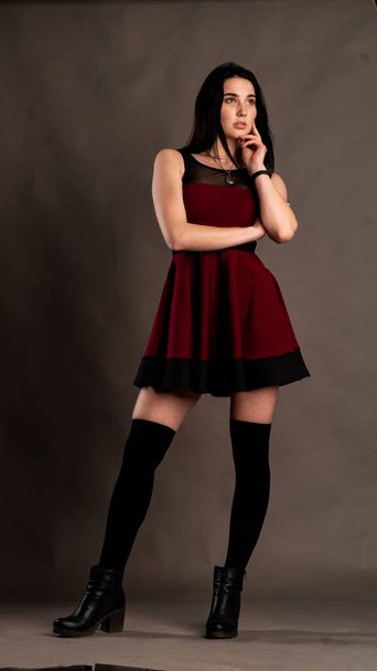 jovencita morenita vestida con estilo en estudio oscuro   - Foto, imagen