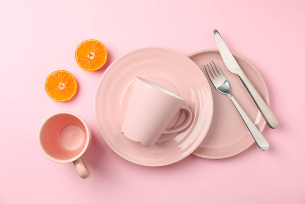 Geschirr und Besteck auf rosa Hintergrund, Draufsicht - Foto, Bild