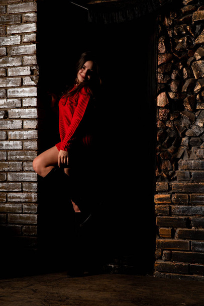 Сексуальная обнаженная женщина в красном свитере на темном фоне    - Фото, изображение