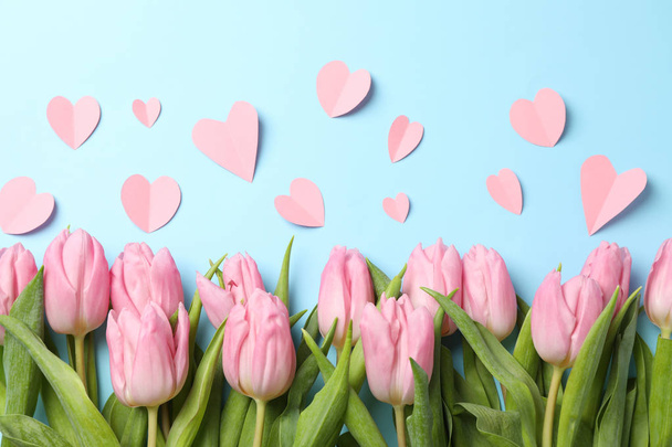 rosa Tulpen und dekorative Herzen auf blauem Hintergrund, Draufsicht - Foto, Bild