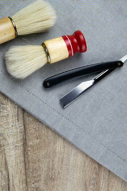 Kit de rasage, concept de coiffeur, brosses en mousse et rasoir dangereux sont disposés sur une serviette rayée
 - Photo, image