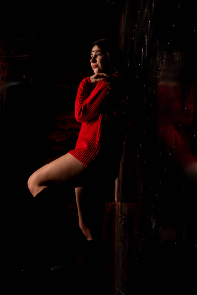 美しいですセクシーヌード女性で赤いセーター上の暗い背景    - 写真・画像