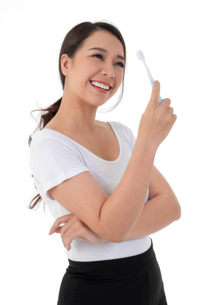 Beautiful Asian woman holding a toothbrush for brush teeth. Her is smile and teeth are white and beautiful and look hygiene. Concept for oral and dental care on the dentist advice - Foto, Imagem