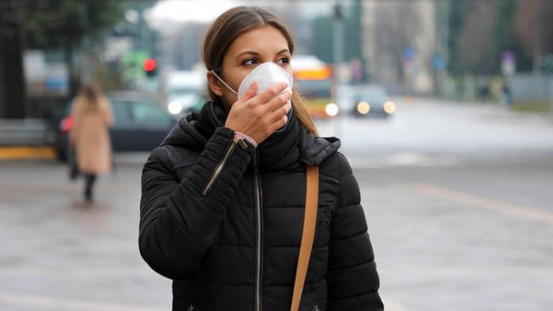 COVID-19 Pandemic Coronavirus Woman in city street wearing face mask protective for spreading of disease virus SARS-CoV-2. Girl with protective mask on face against Coronavirus Disease 2019. - Zdjęcie, obraz