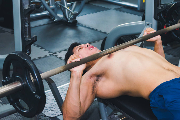 Asian muscular men are lifting weights in the gym. - Photo, Image