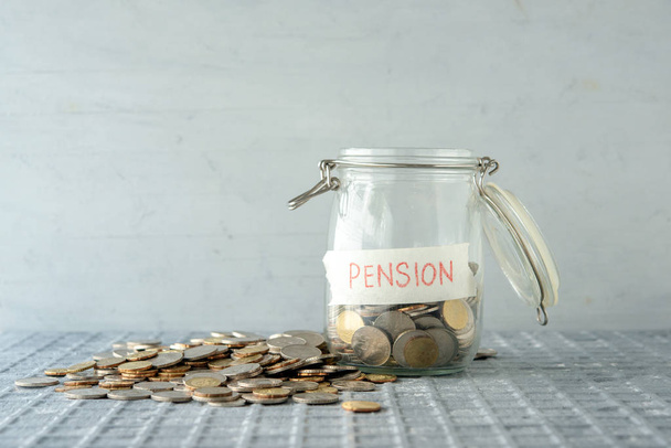 Coins in glass money jar with pension label, financial concept. - Photo, image