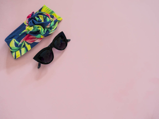 Headband com óculos de sol sobre fundo rosa com espaço de cópia
 - Foto, Imagem