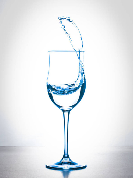 water splashing from wineglass on white background - Fotó, kép