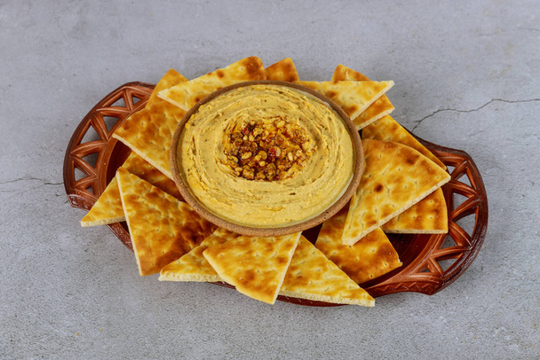 Healthy snack with hummus dip, pita bread slices on plate. - Foto, afbeelding