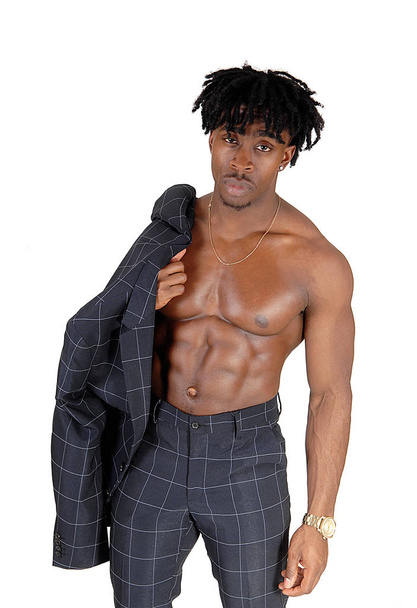 A young alethic black man standing shirtless with his suit jacket over.his shoulder, showing his great body, isolated for white background. - Foto, Imagem