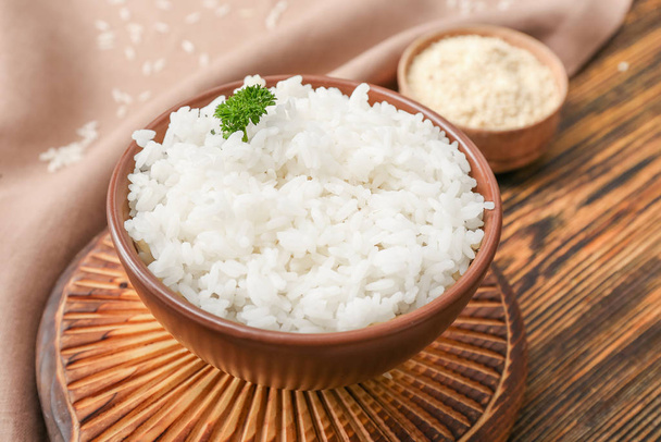 Boiled rice in bowl on wooden table - Φωτογραφία, εικόνα