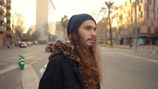 Portret długowłosego hipstera spacerującego ulicą we współczesnym mieście - Materiał filmowy, wideo