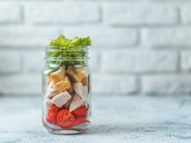 Caesar salad in glass mason jar on gray background. Copy space for text. Homemade healthy caesar salad layered in jar. Healthy food, trendy modern food, diet concept, idea, recipe. - Fotografie, Obrázek