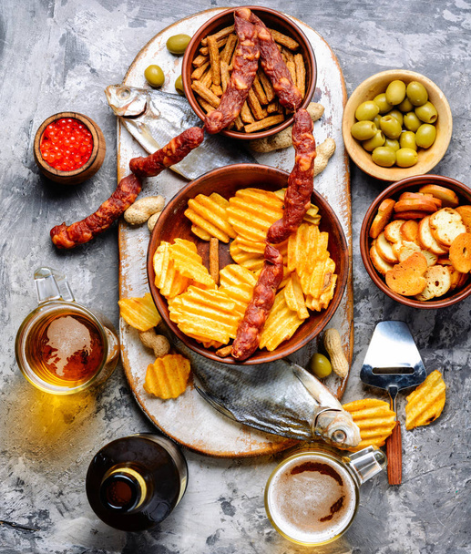 Selection of beer and snacks.Chips, fish, beer sausages on the table - Foto, Bild