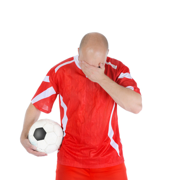 Upset soccer player in the red form. - Фото, изображение