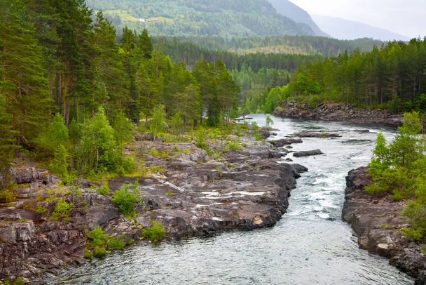 Bergfluss mit einem Wasserfall in Norwegen. Landschaft Norwegens. Sommerlandschaft in den Bergen Norwegens. - Foto, Bild