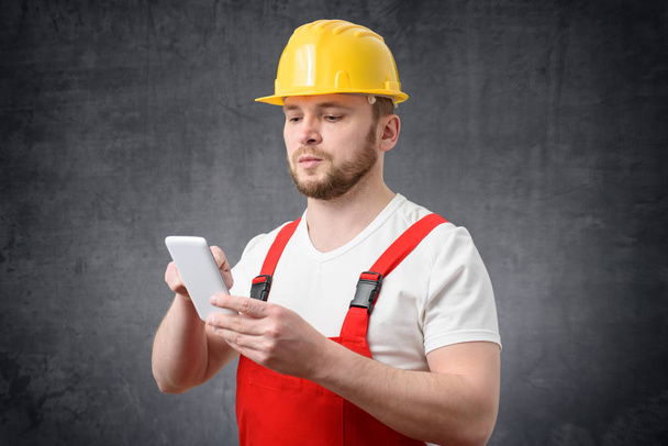 Portrait of a construction worker using smartphone - Photo, Image