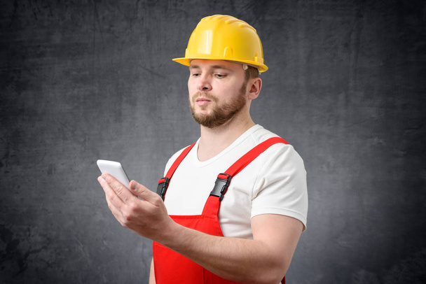 Portrait of a construction worker using smartphone - Zdjęcie, obraz